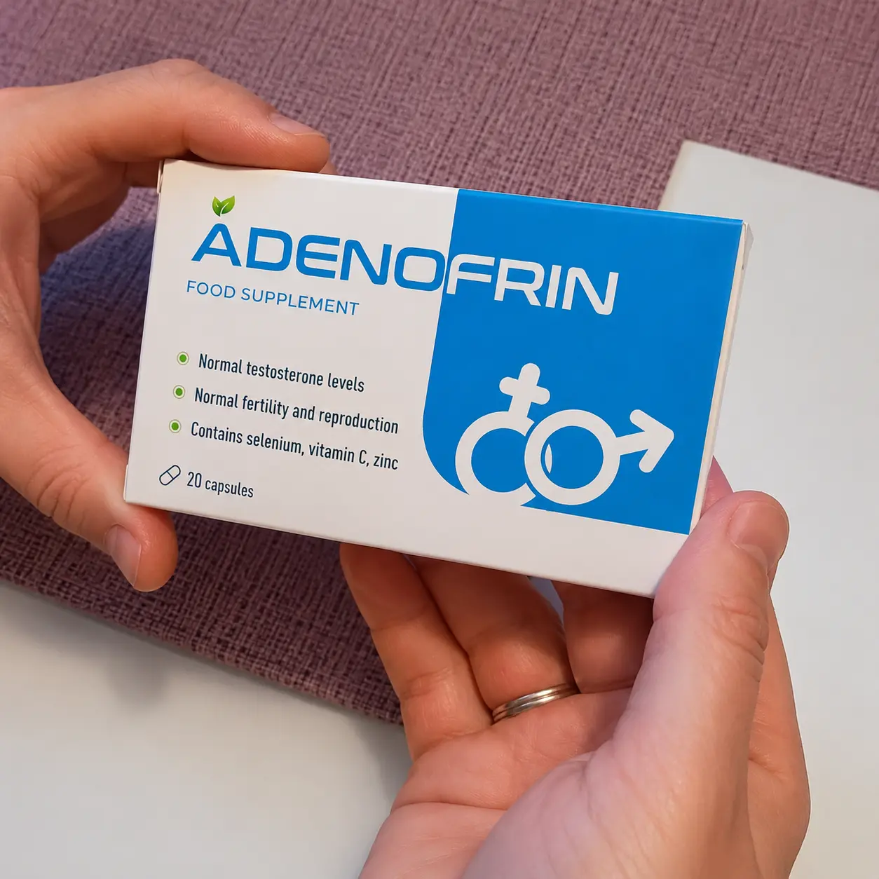 Caja de Adenofrin sostenida con ambas manos en una foto real